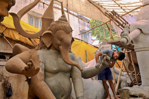 Free An artisan skillfully works on a Ganesha statue in a traditional Indian workshop in Surat. Stock Photo
