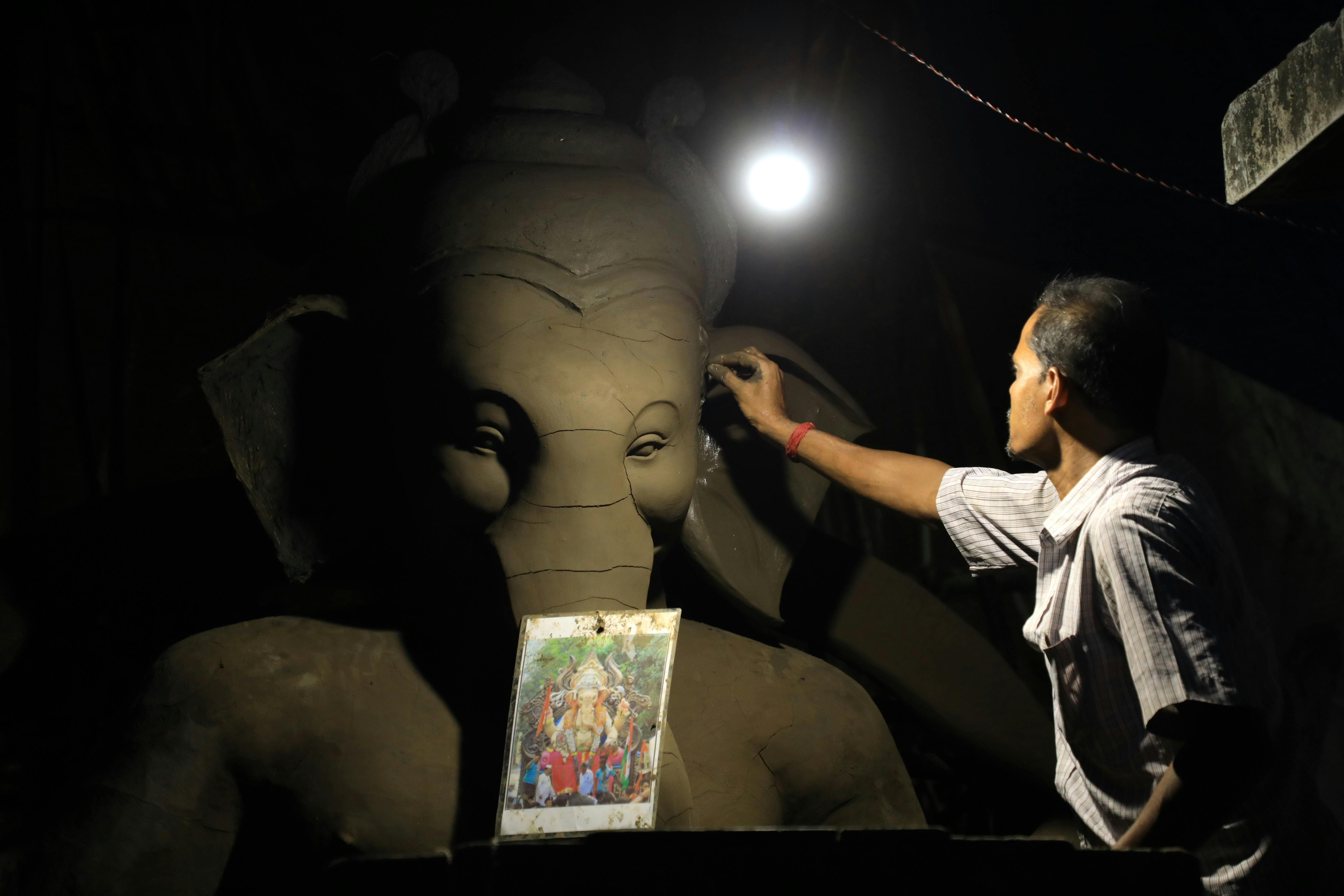 Free A Man Touching the Statue Stock Photo