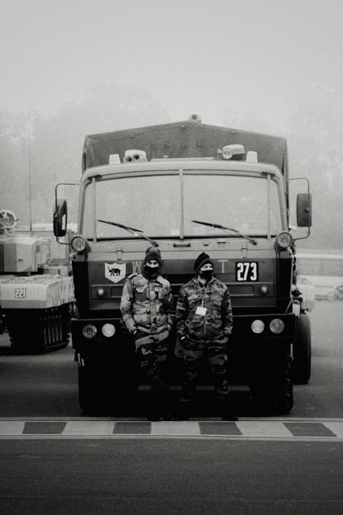 Soldiers Standing by Military Truck
