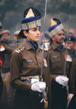 Indian military officers in uniform stand in formation, holding swords, showcasing discipline and honor.