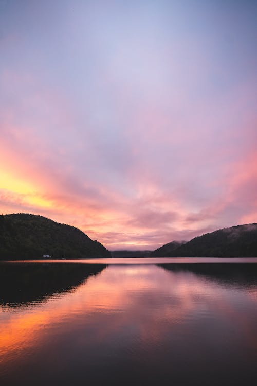 Lake Near Mountains Under Purple Sky