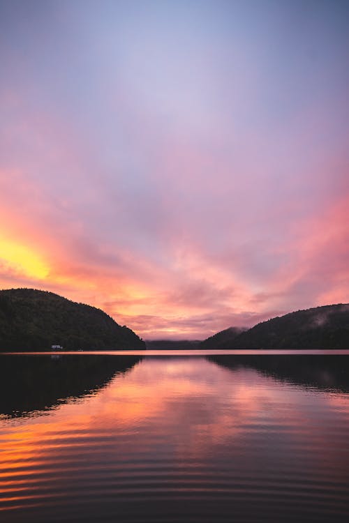 Calm Lake near Mountains during Sunset