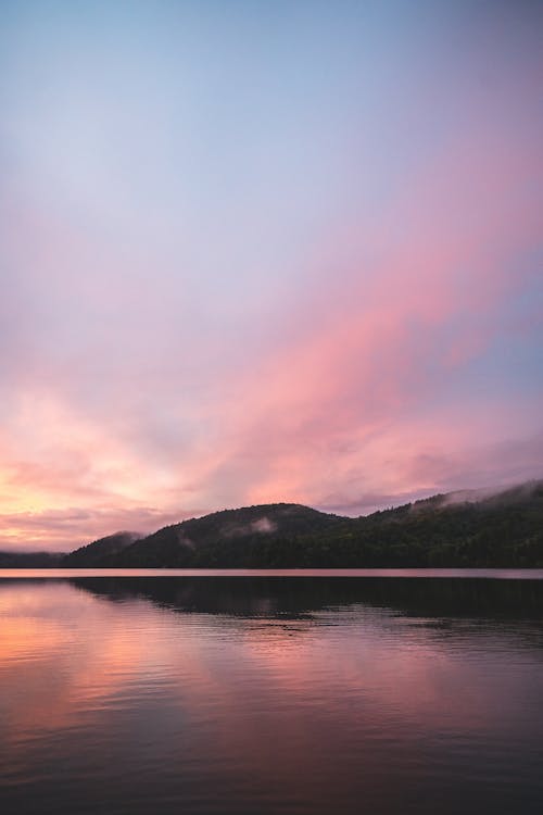 Lake Near Mountains Under Purple Sky