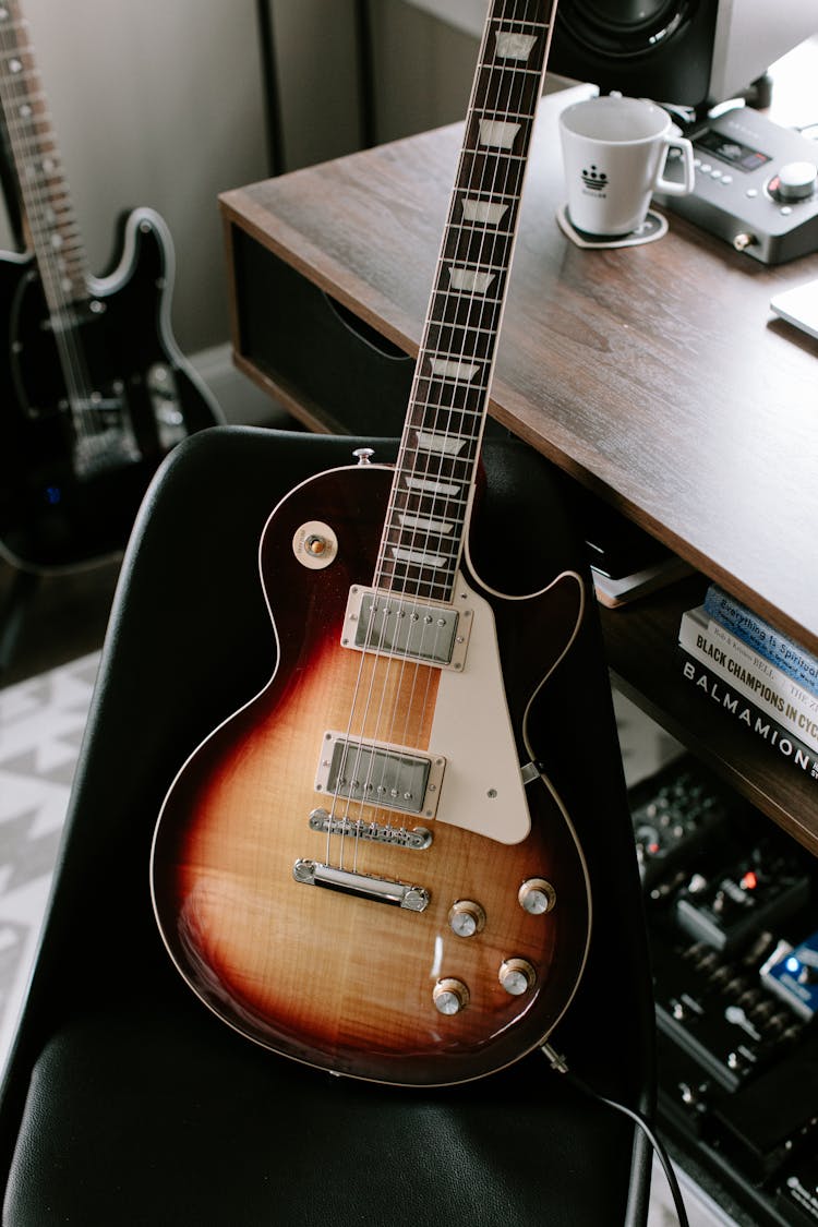 Electric Guitar On Chair By Desk