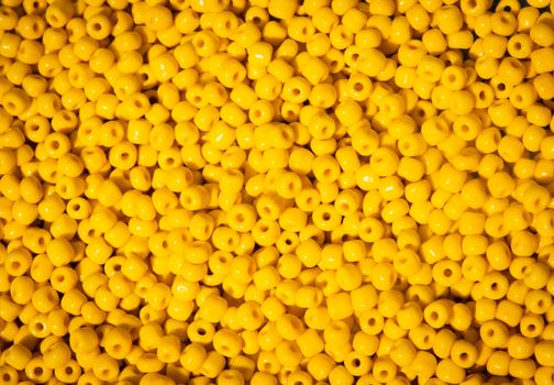 A vibrant collection of glossy yellow beads perfect for crafts and DIY projects.