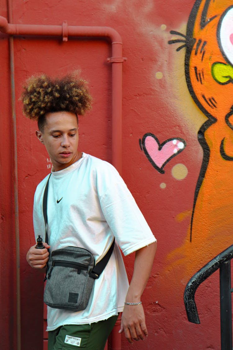 Young Man In Trendy Casual Clothing Against A Graffiti Wall 