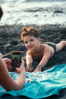 Adorable child playing on a black sand beach, captured in a candid vacation moment.