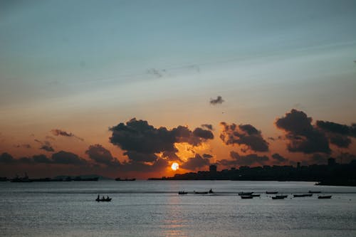 Silhouette of Boats on Sea during Sunset