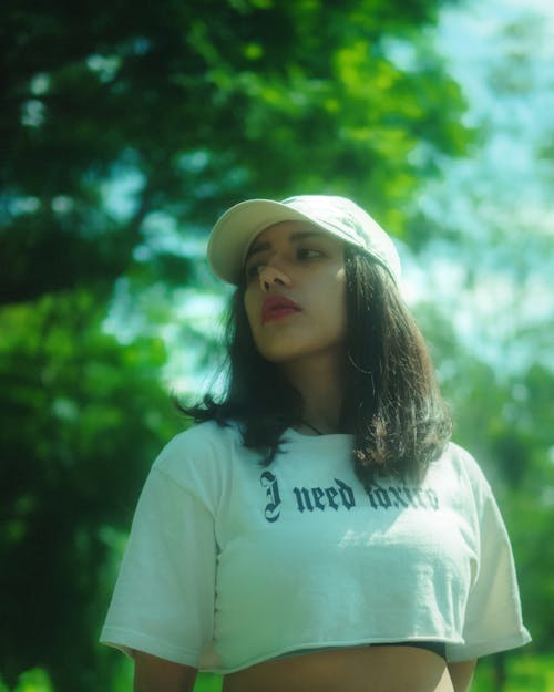 Woman in White Crop Top and Cap looking Away