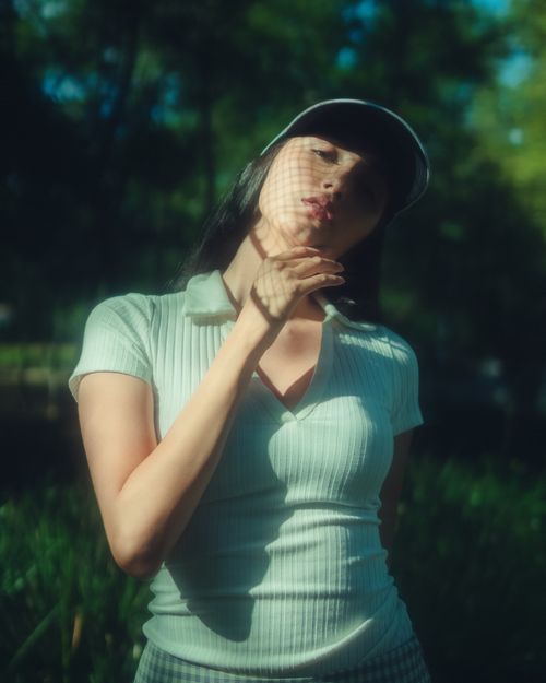 Free Woman in casual attire posing thoughtfully outdoors under gentle sunlight, creating a serene and artistic expression. Stock Photo