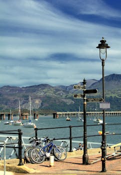 美丽的沿海景观，以自行车、船只和风景优美的山脉为背景
