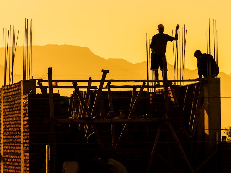 Silhouette Of Workers On Construction Site