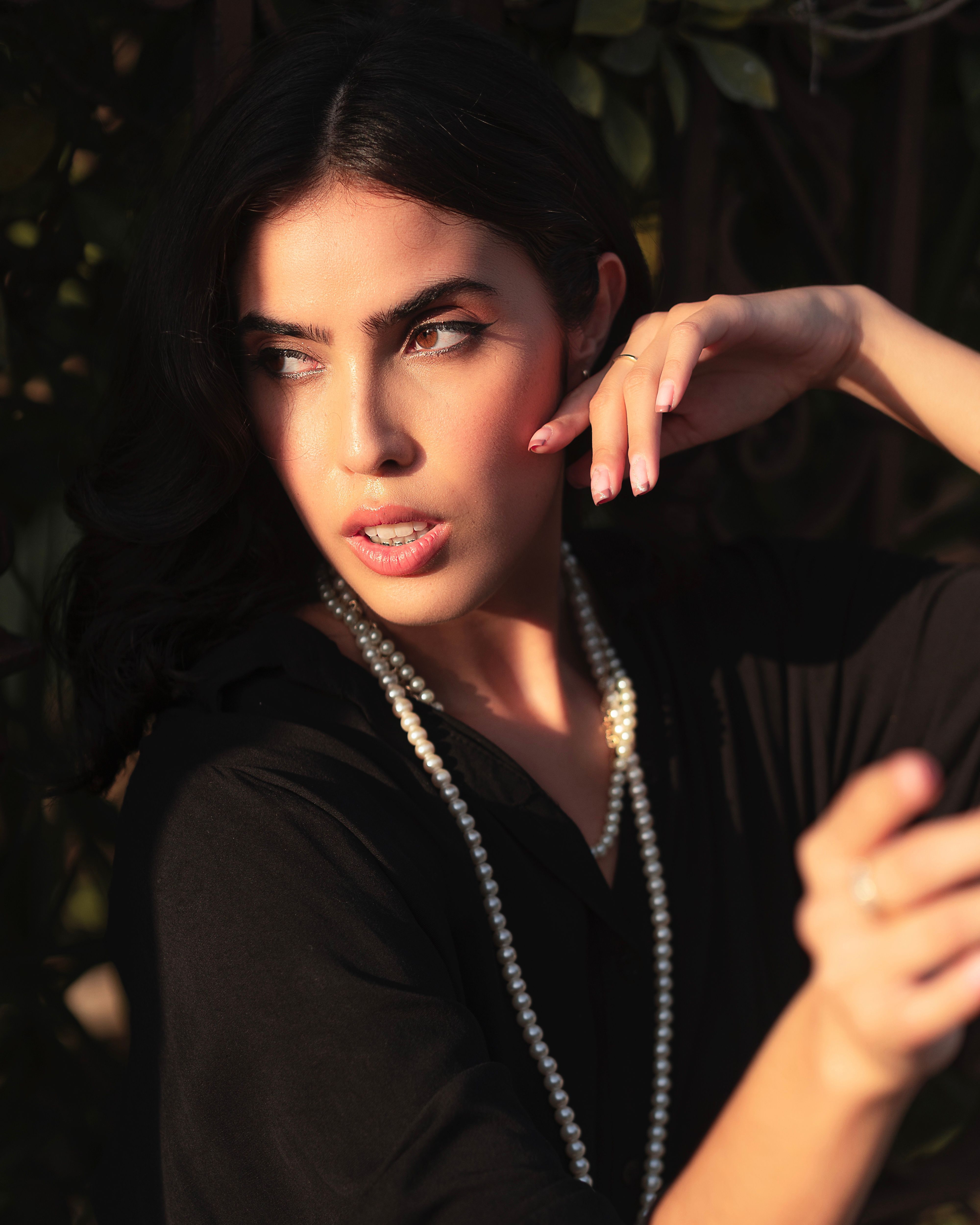 Woman in a Black Shirt Wearing a Pearl Necklace · Free Stock Photo