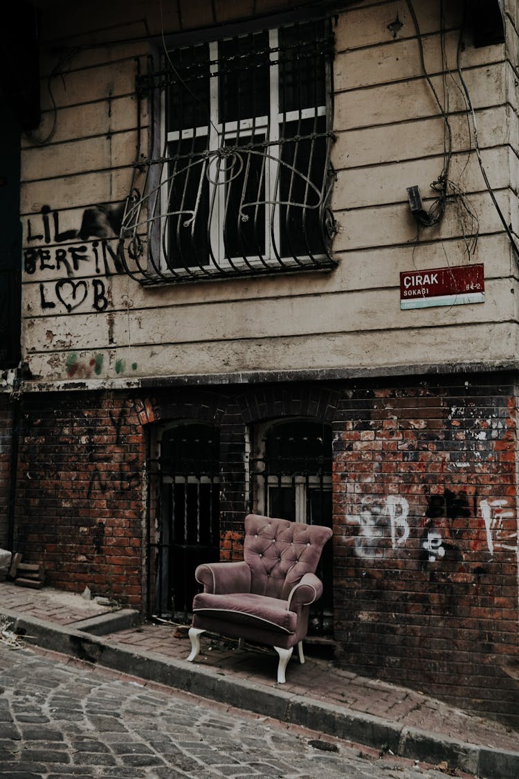 Pink Sofa Chair Outside A Brick And Concrete Building