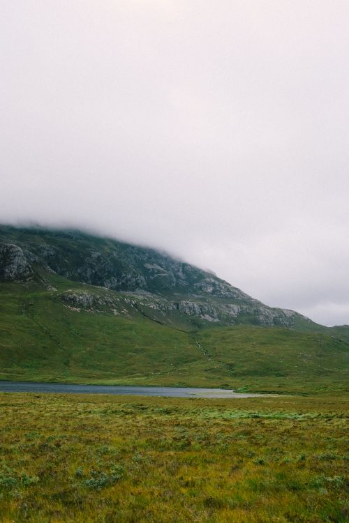 Free Serene landscape of a misty mountain covered by clouds, captured on a foggy day. Stock Photo