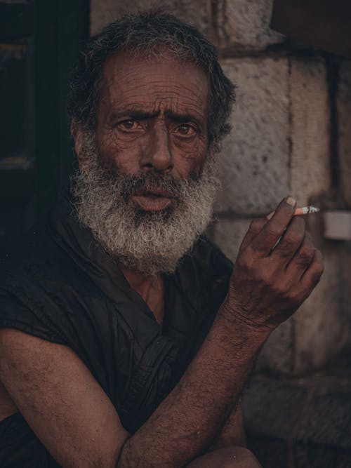 An Elderly Man Smoking a Cigarette