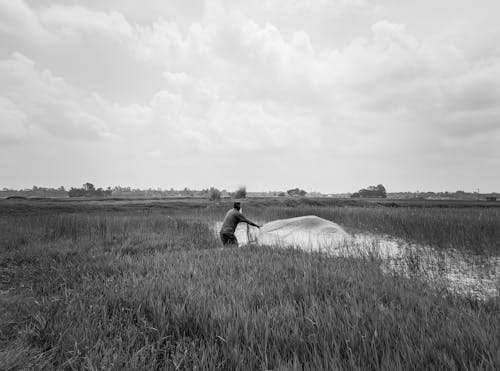 Grayscale Photo of Man Working on a Field