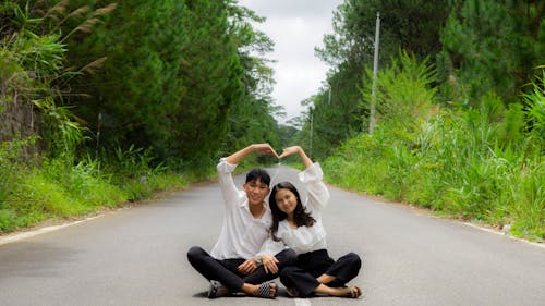 Couple Sitting and Posing on Road