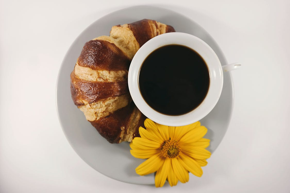 免费 杯咖啡在板上的面包旁边 素材图片