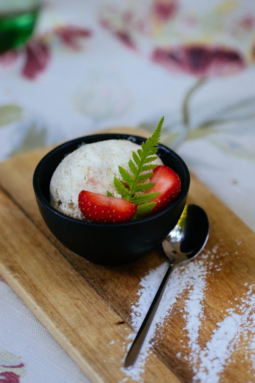 Free Ice Cream Served on Black Bowl With Spoon Stock Photo