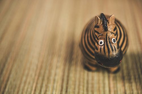 Free Charming handmade zebra figurine on a textured surface. Perfect for decor and crafts. Stock Photo