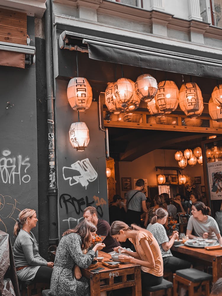 People Eating At Table On Restaurant Outdoor Terrace