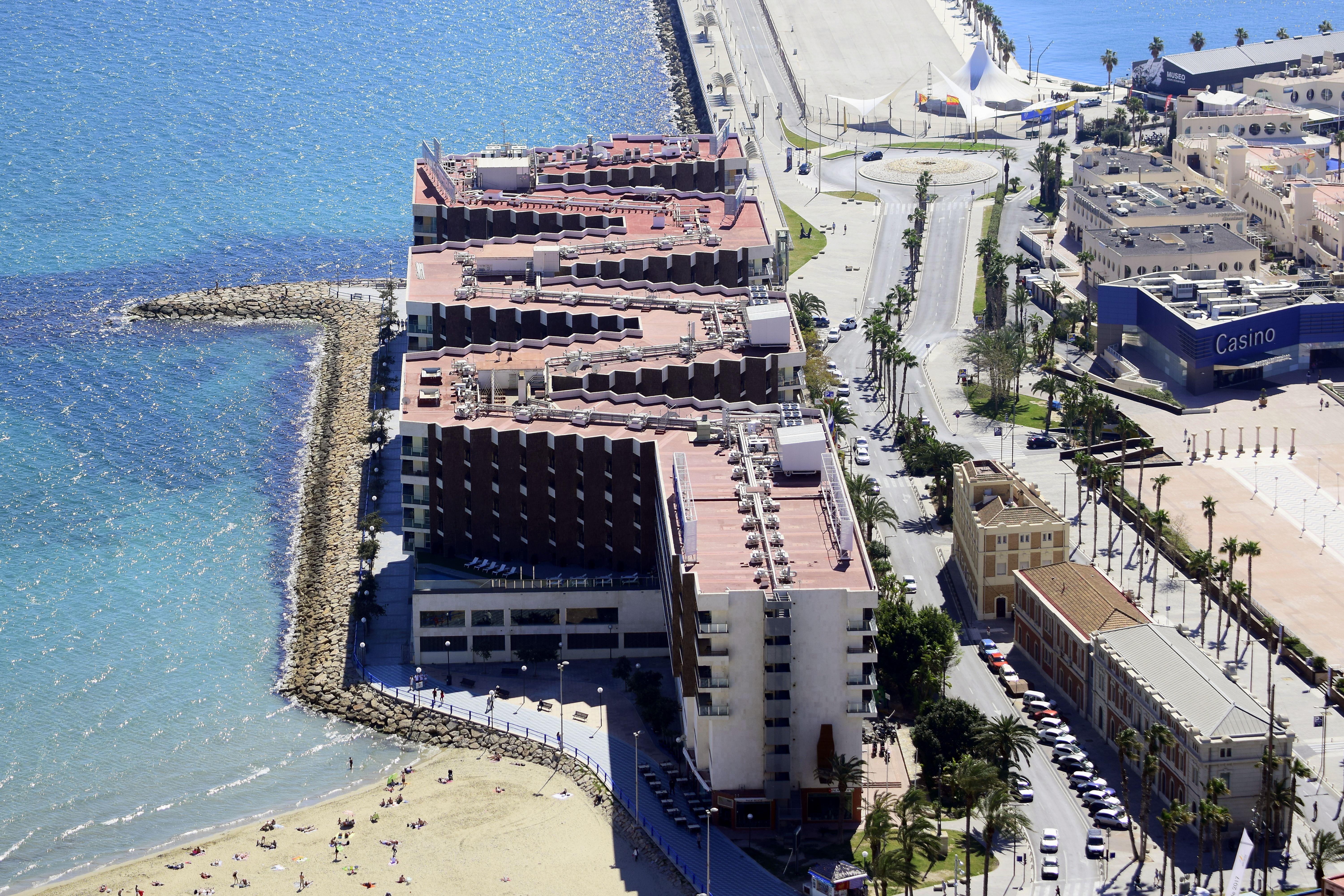Aerial view of coastal city with buildings, beach, and casino.