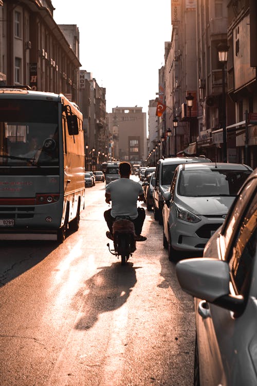 Man on Motor Scooter among Cars on Street