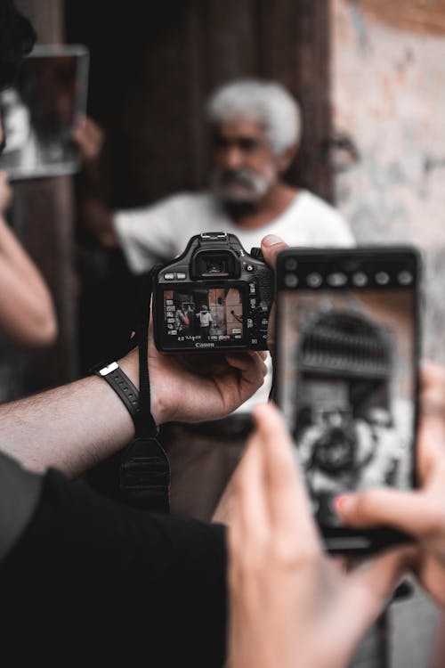 Photographers Taking Photo of an Old Man Using Digital Camera and Smartphone