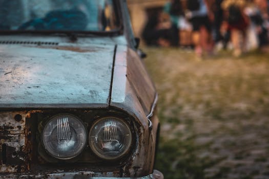 Detailed shot of a rusty vintage car with focus on the headlight, evoking nostalgia.