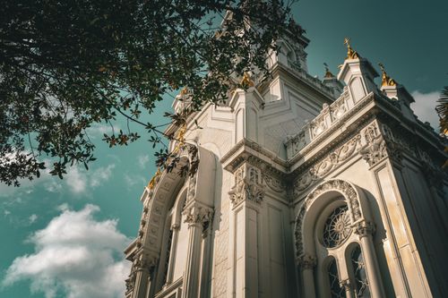 Free Low angle shot of an ornate church tower with intricate details against a clear blue sky. Stock Photo