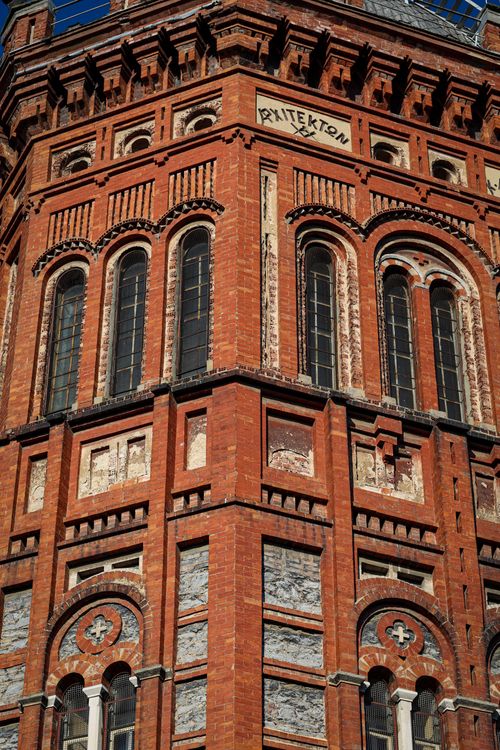 Free Close-up of a red brick church facade showcasing Gothic architecture and arched windows. Stock Photo