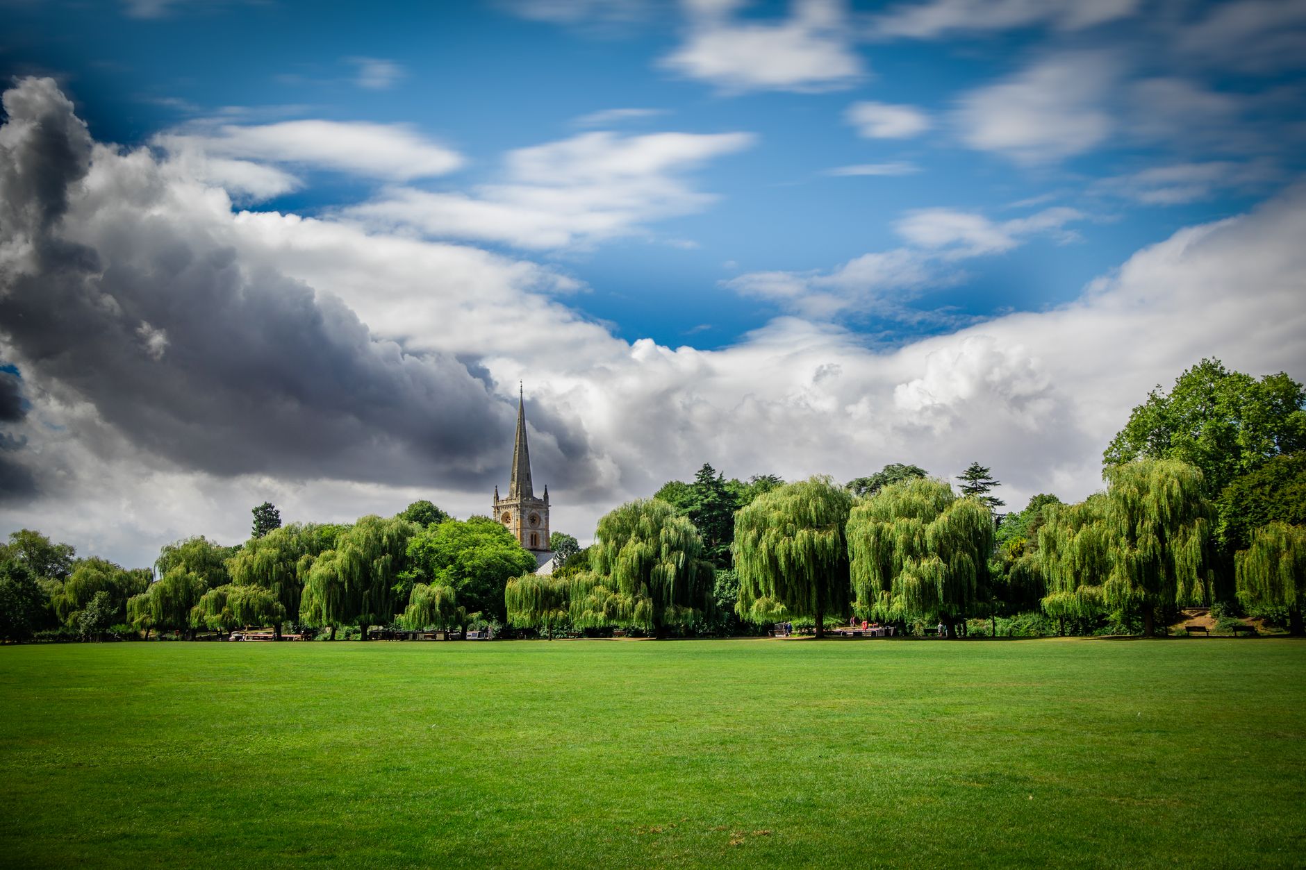 St. Mary's Church surrounded by lush greenery and clear blue skies in Stratford-upon-Avon