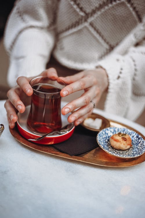 A Person Holding Clear Glass Mug Cup