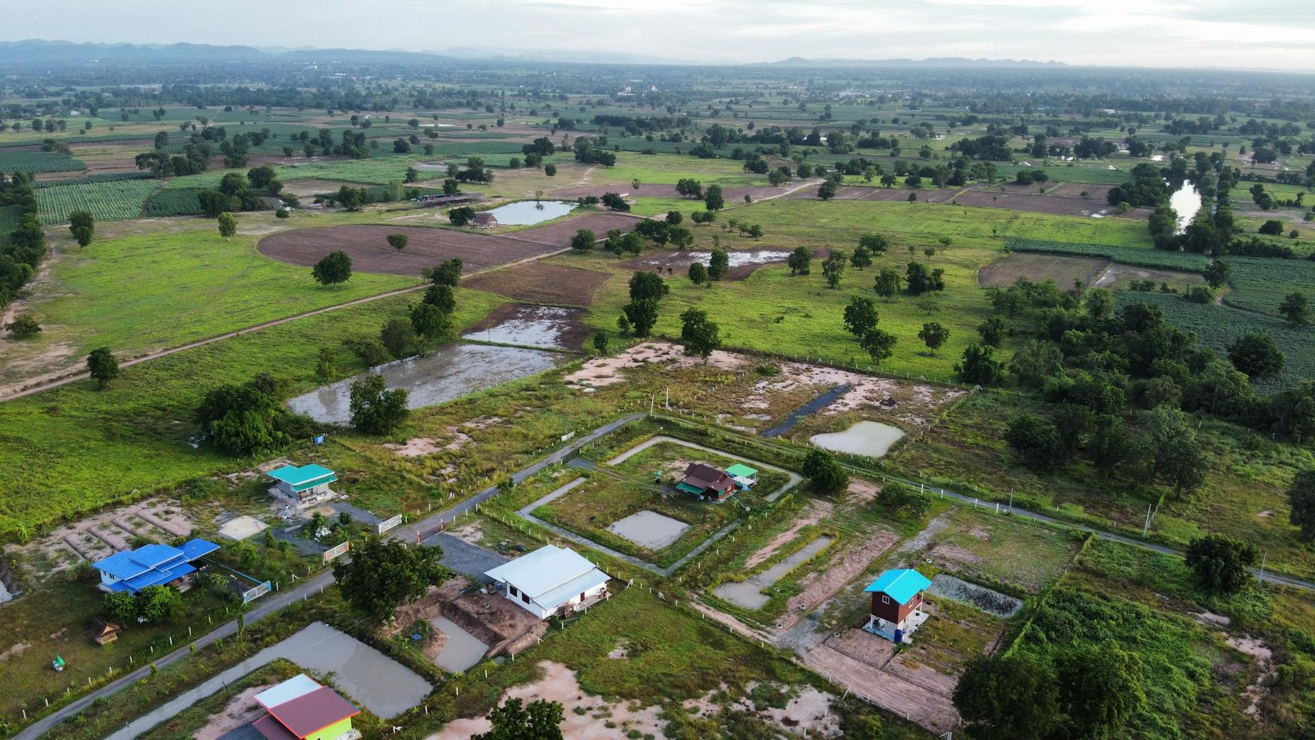 A picturesque aerial view of a rural farm landscape with fields and ponds.