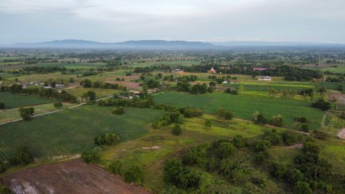 Free Scenic aerial view of a vast countryside with green fields and distant mountains. Stock Photo