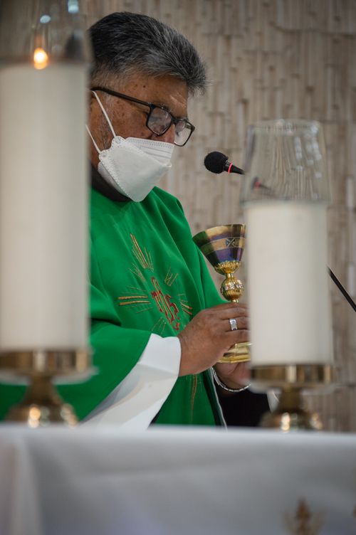 Free A priest wearing a mask holds a chalice during a Catholic mass in Guayaquil, Ecuador. Stock Photo