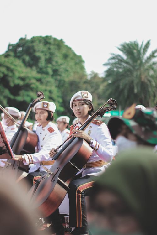 Free Young musicians in uniform playing string instruments outdoors in Jakarta. Stock Photo