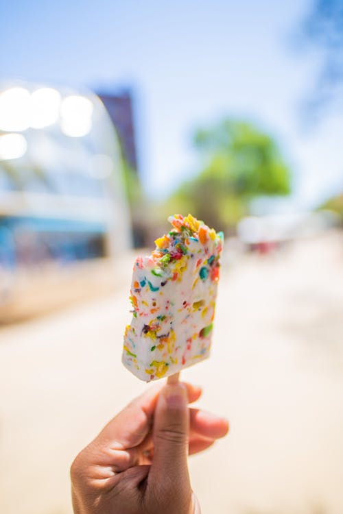 Person Holding a Colorful Ice Cream on a Stick