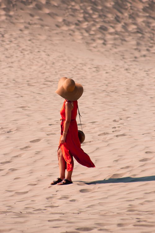 Woman in Red Dress Standing on Sand Dunes on a Desert