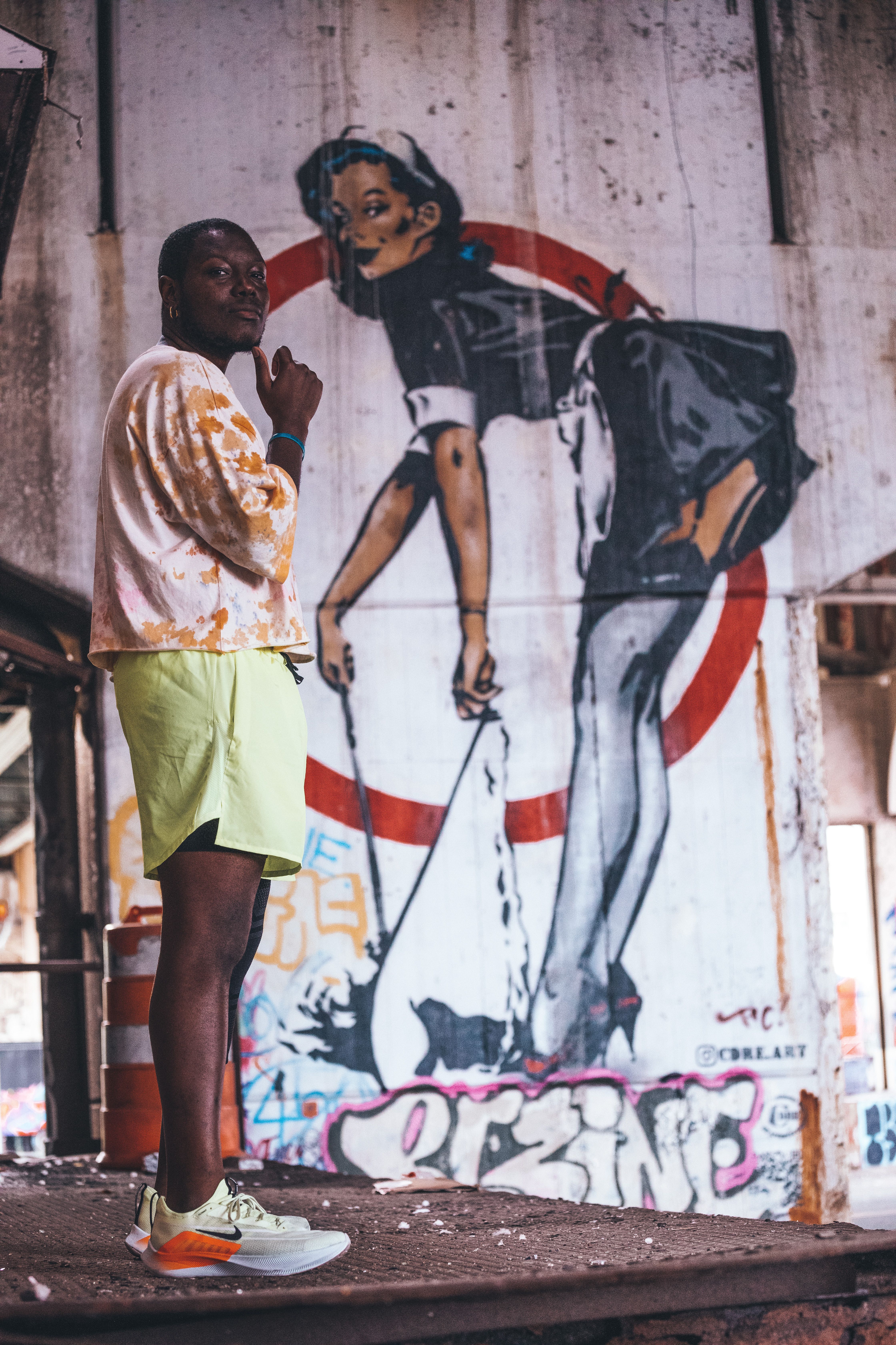 Stylish man in urban setting against vibrant street graffiti background.