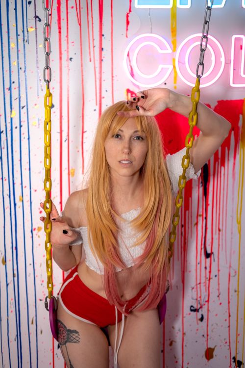 Free Dynamic portrait of a woman with long hair on a colorful swing, vibrant background. Stock Photo