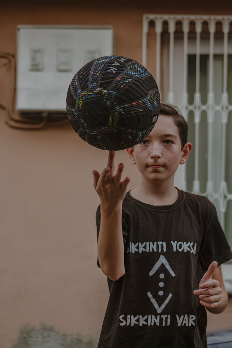 Boy In Black Shirt Spinning Ball On Finger