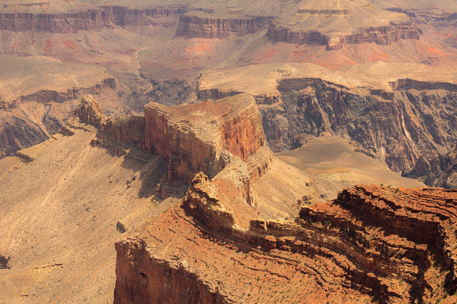 Aerial view of the Grand Canyon rim, showing dramatic cliffs and layered rock formations.