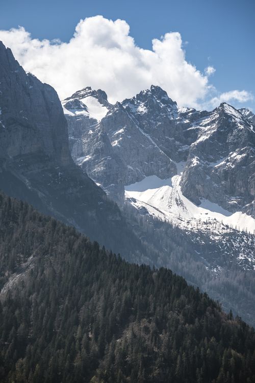 Free Stunning view of snow-covered mountains under a bright blue sky with fluffy clouds. Stock Photo