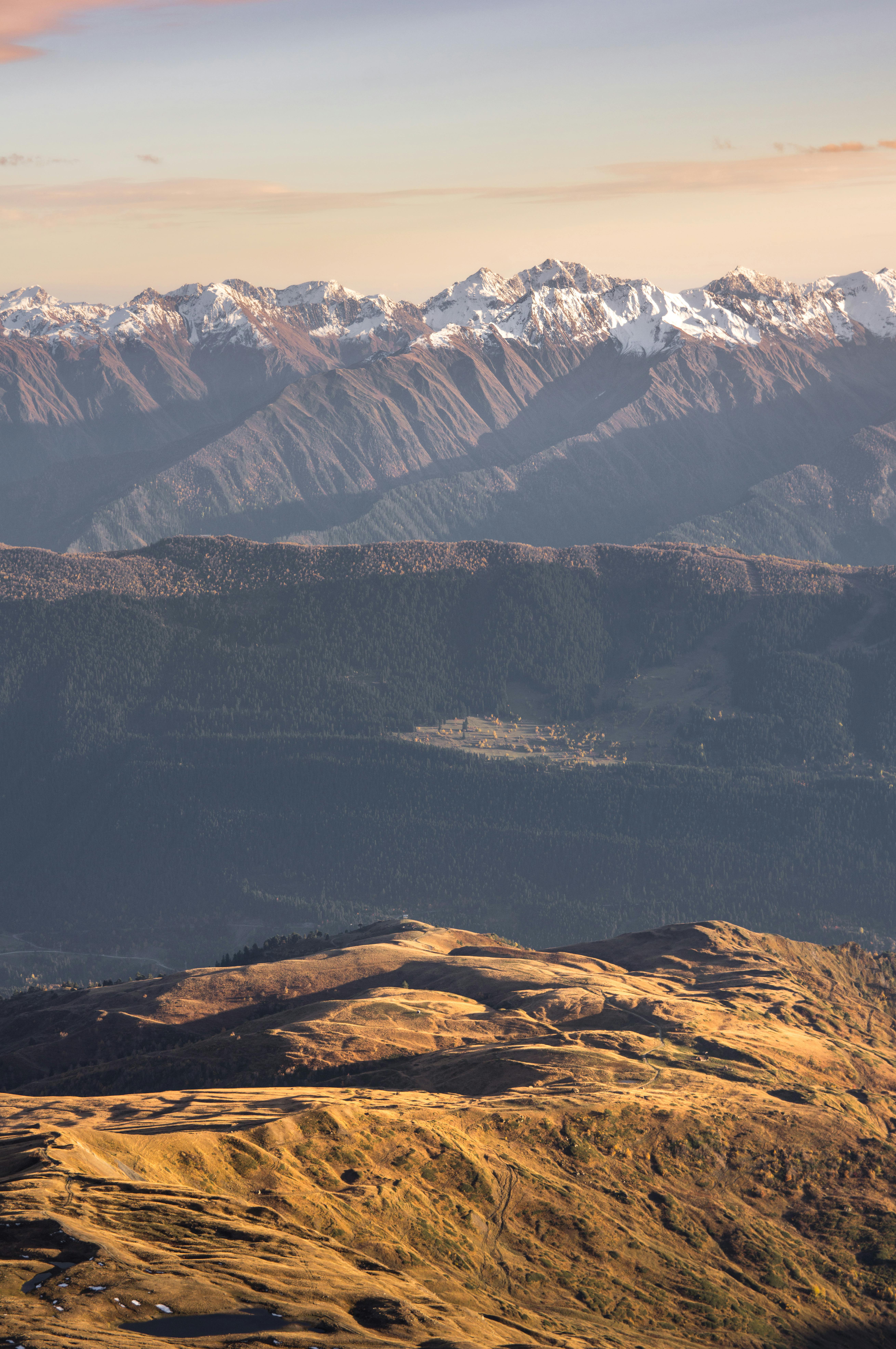 Stunning view of sunlit mountain range with snow-capped peaks in the distance.
