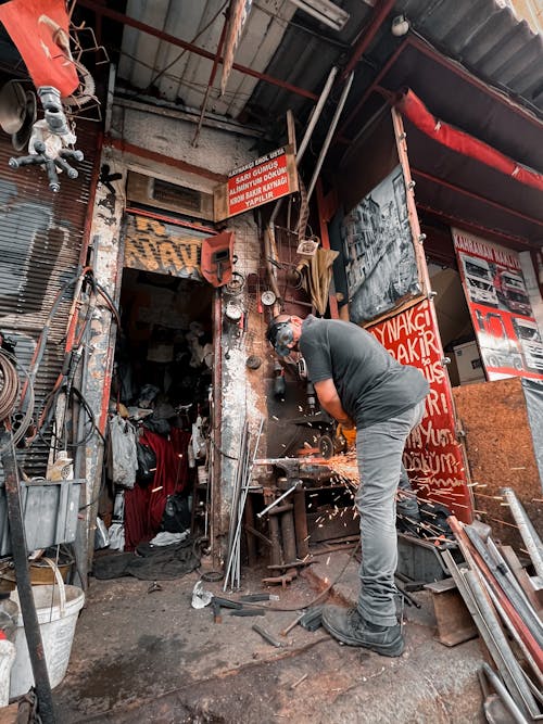 Man in a Workshop Using a Grinder 