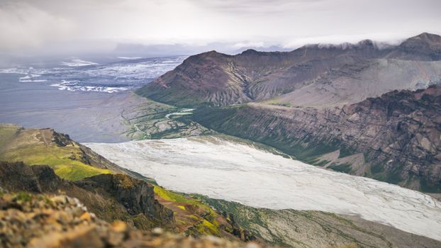 Breathtaking view of Icelandic glacier, river, and mountains.