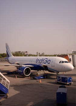 IndiGo airplane on tarmac at Bengaluru Airport, ready for boarding with clear skies.