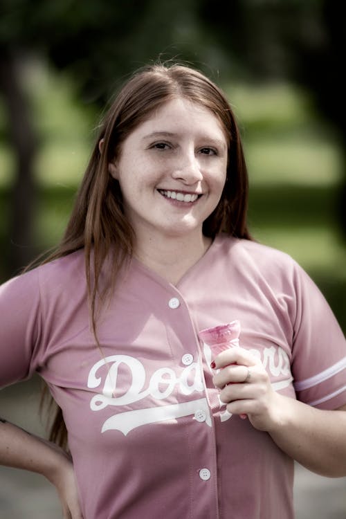 Smiling Woman in Pink Jersey Holding a Ice Cream Cone